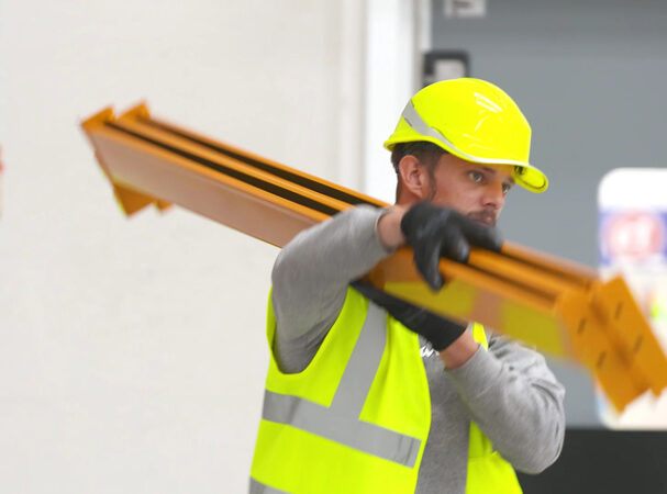 racking regulations blog - WSL A racking installer carrying some racking beams in line with racking regulations